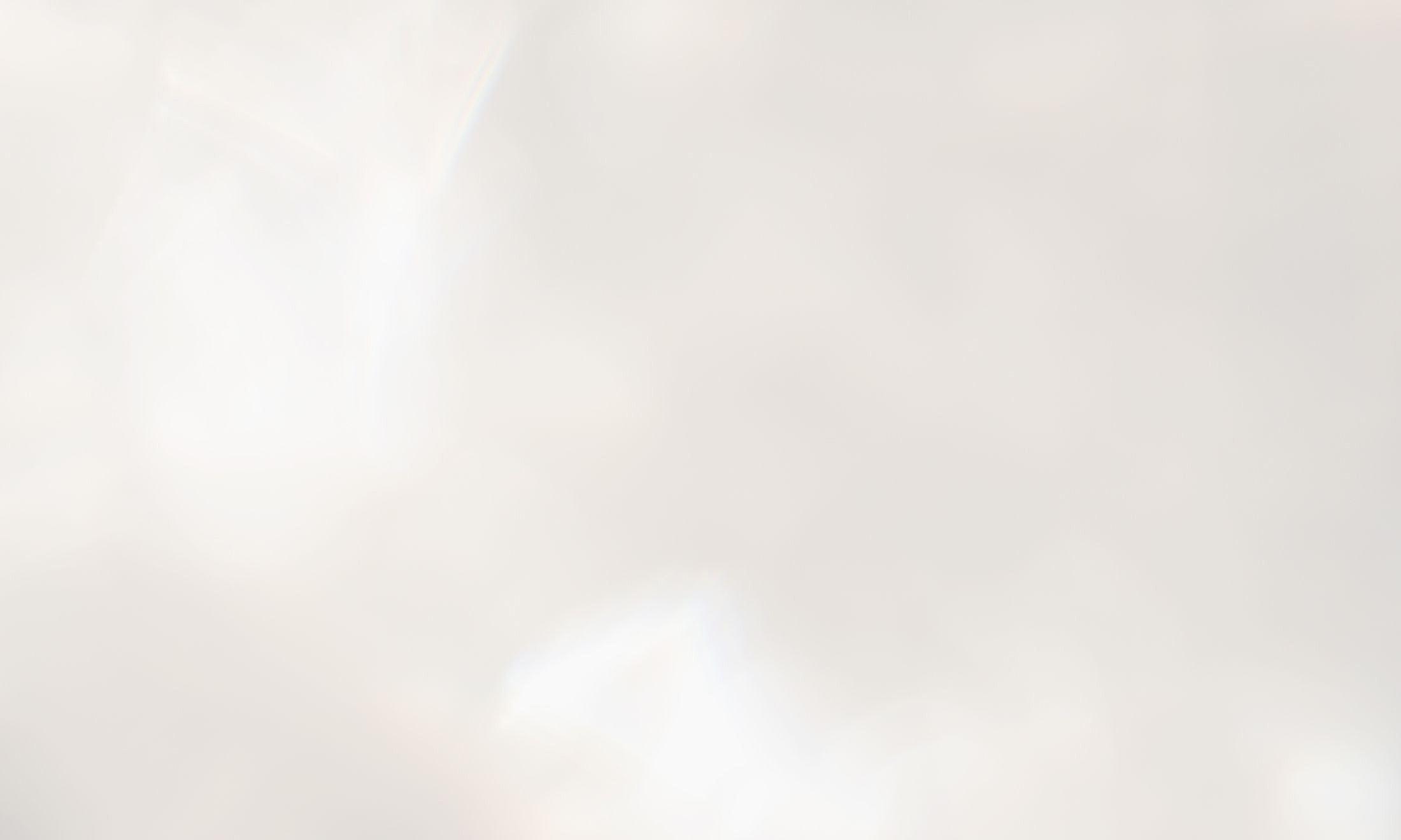 Abstract soft white background with subtle highlights.