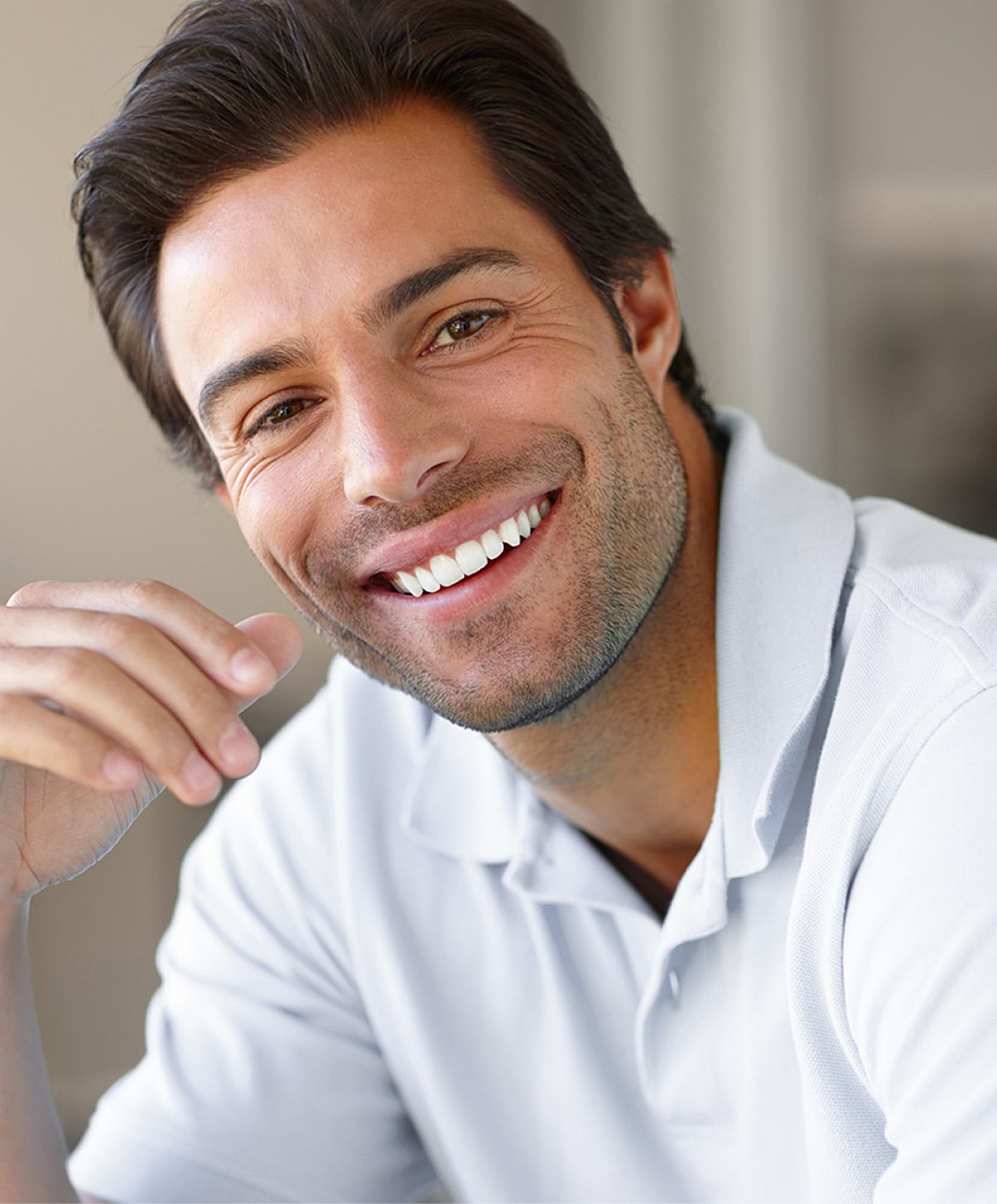 Smiling man wearing a light polo shirt.