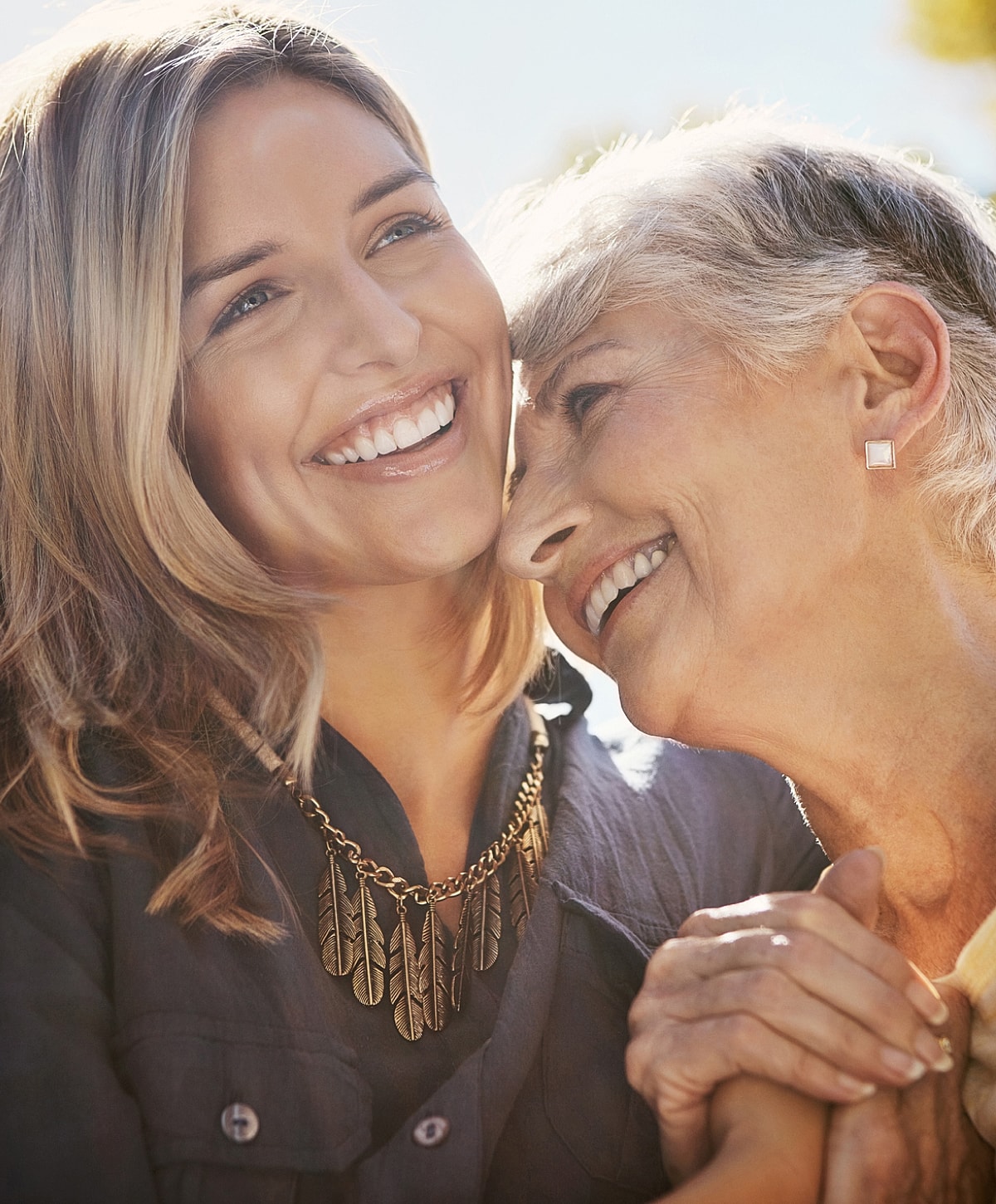 Smiling woman and elderly person sharing affection.