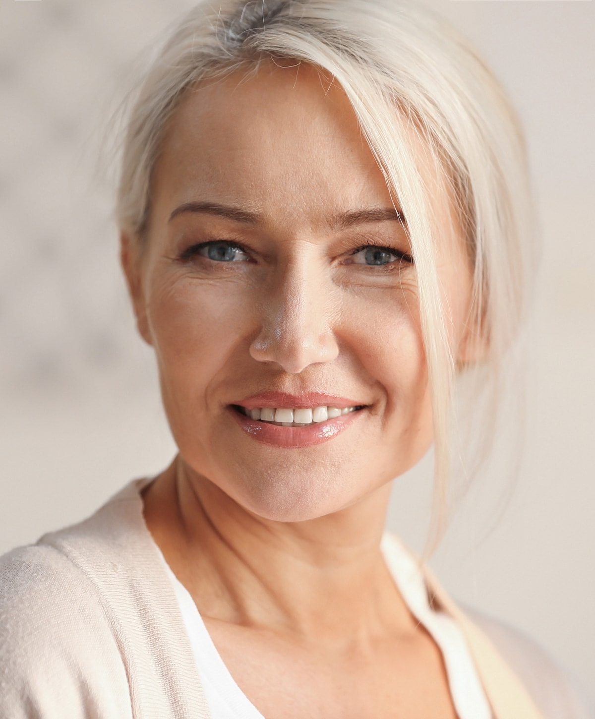 Smiling woman with light hair and clear eyes.