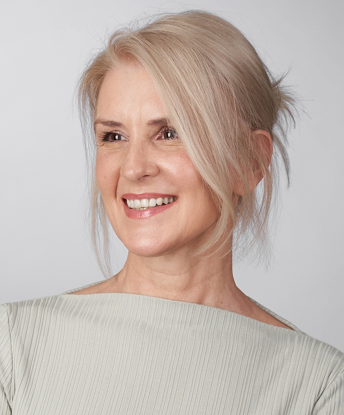 Smiling woman with blonde hair and light top.
