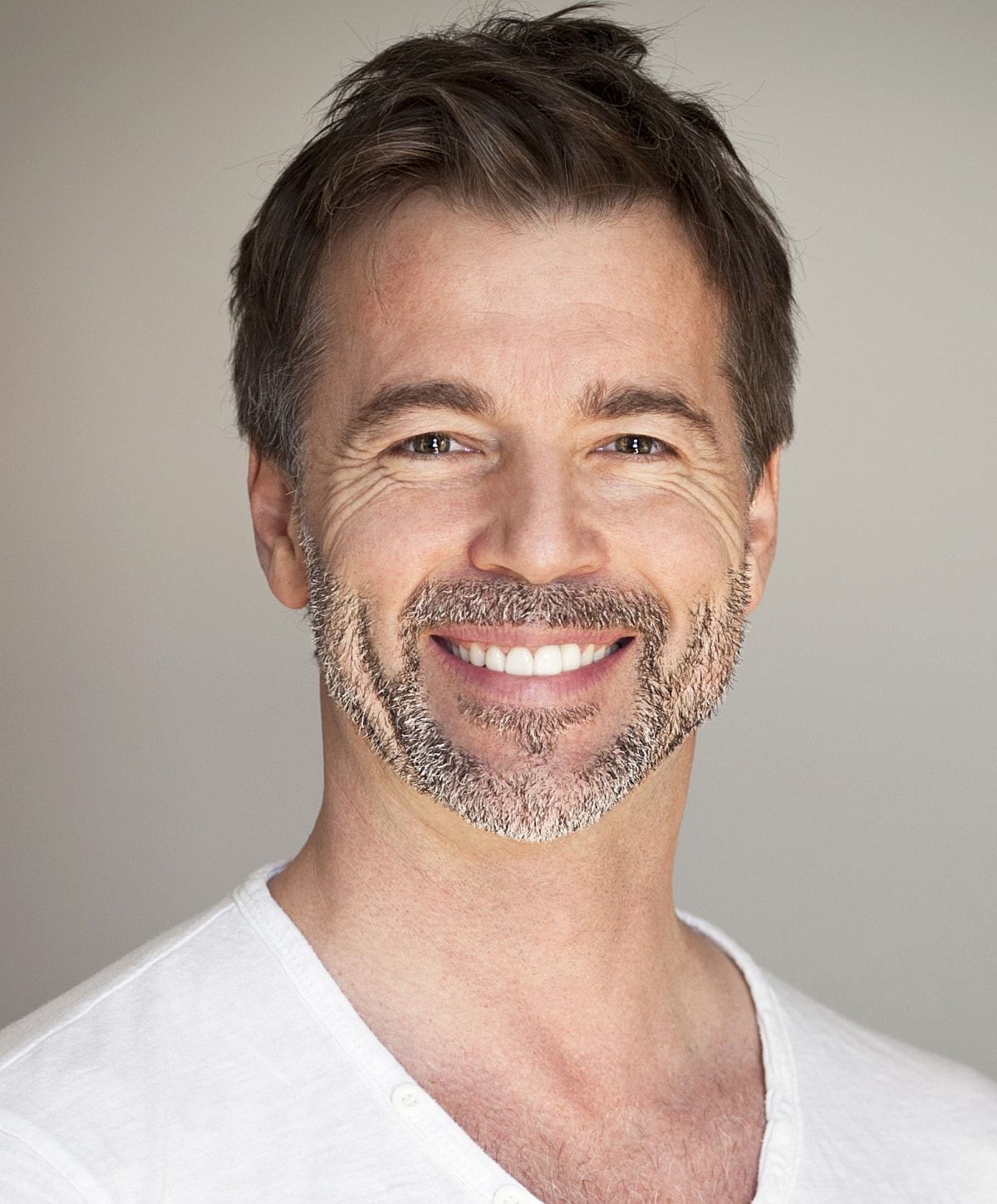 Smiling man with light beard and casual attire.