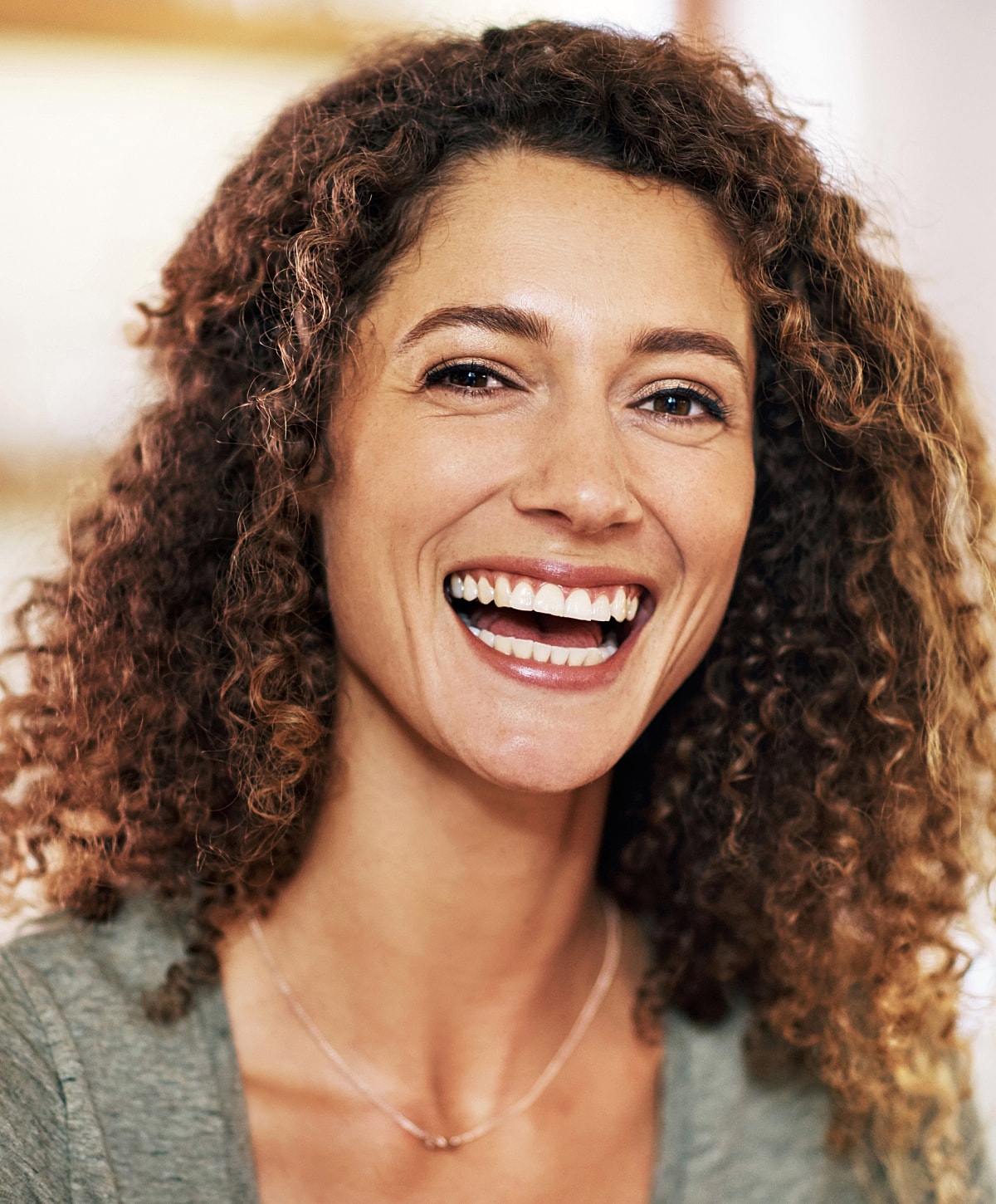 Smiling woman with curly hair in candid moment.