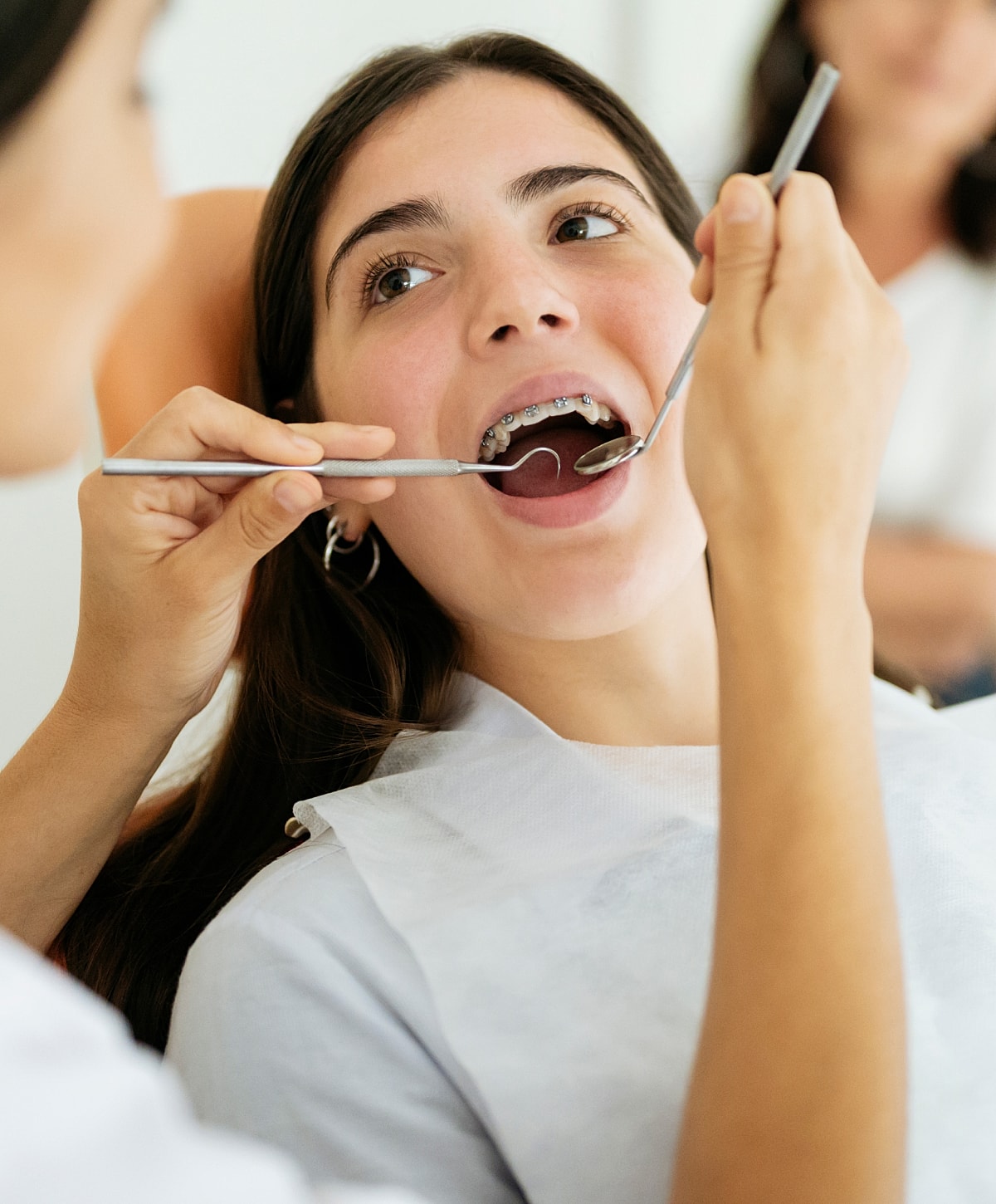 Girl in dental chair with orthodontic tools.