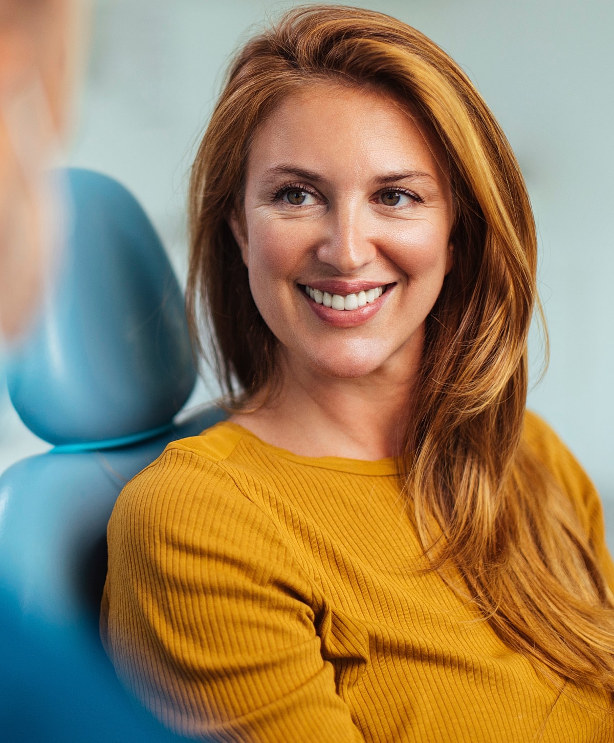 Smiling woman in a dental office setting.