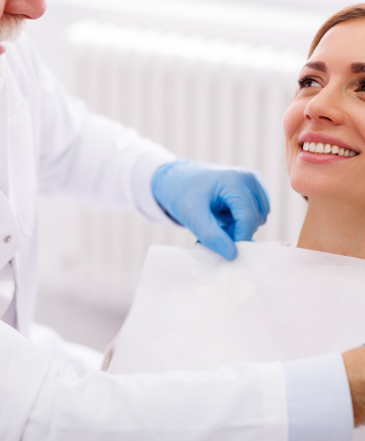 Patient preparing for dental examination, smiling.