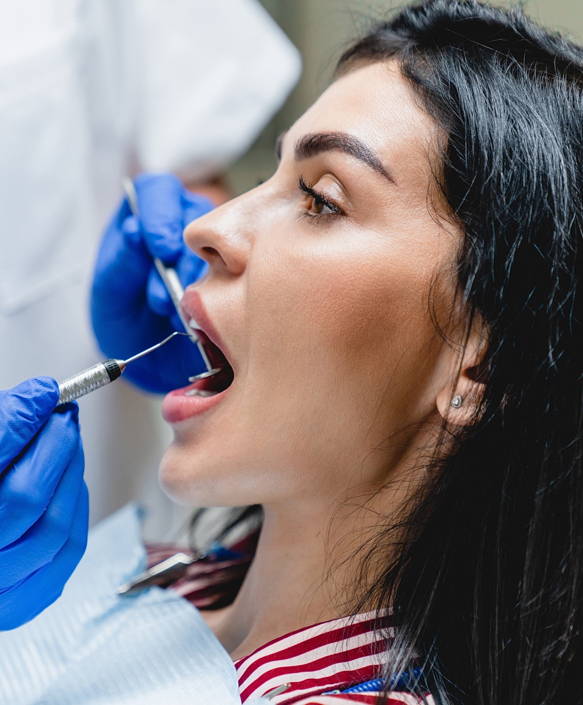 Woman receiving dental treatment in clinic setting.
