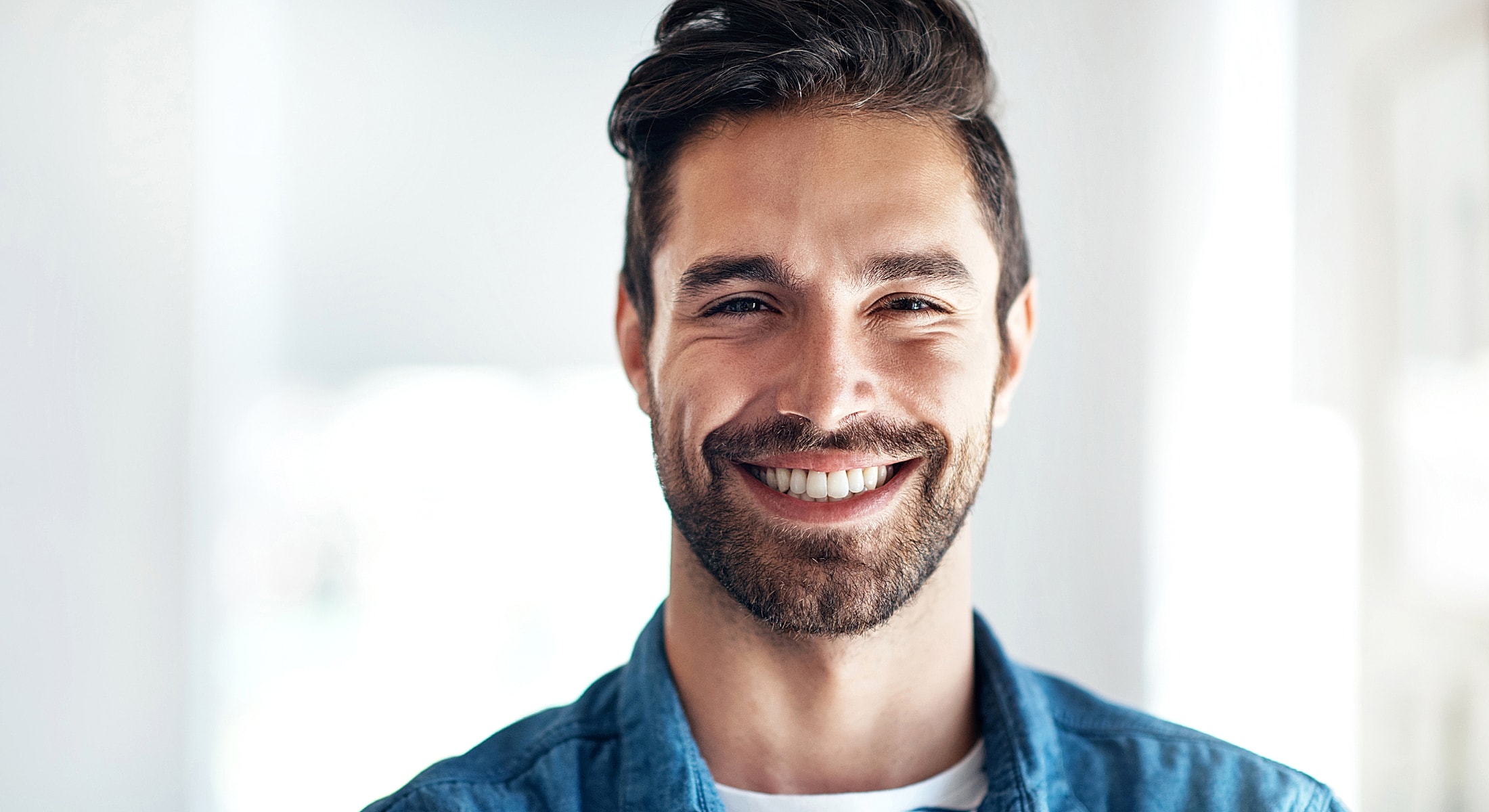 Smiling man in casual attire indoors.