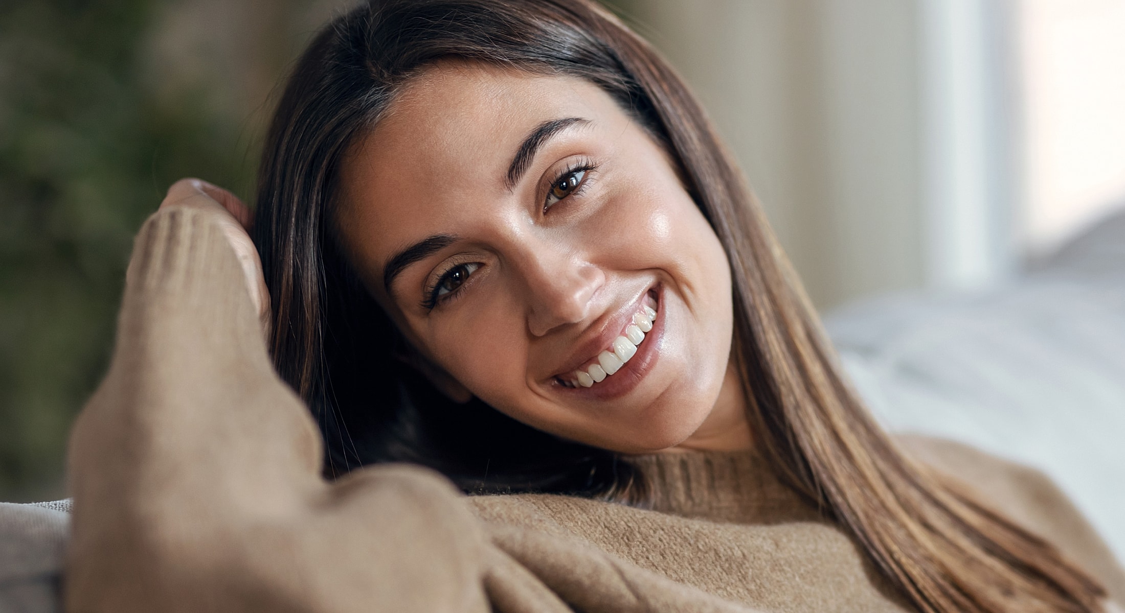 Smiling woman relaxing on a couch.