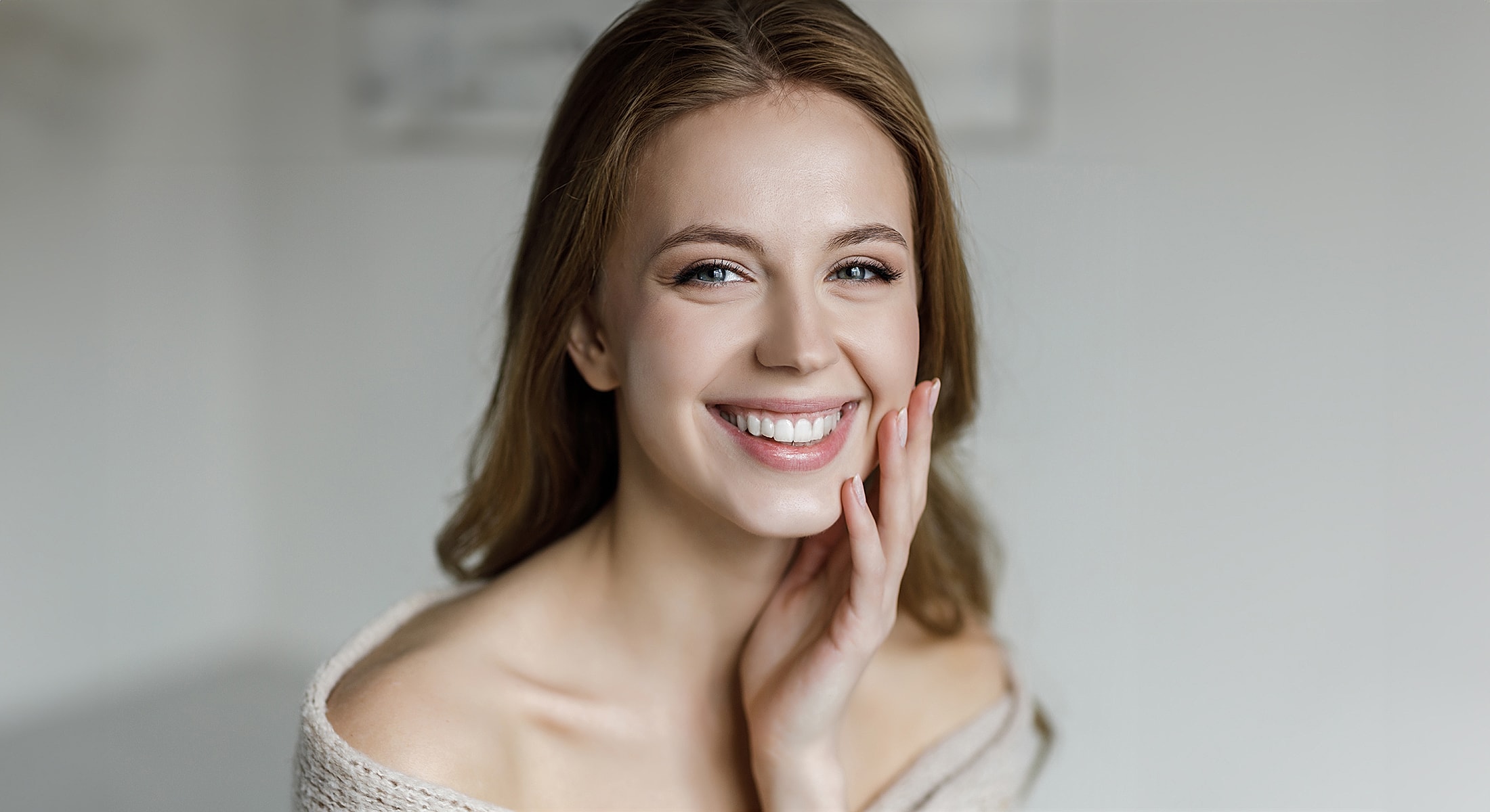 Smiling woman with long hair and natural makeup.