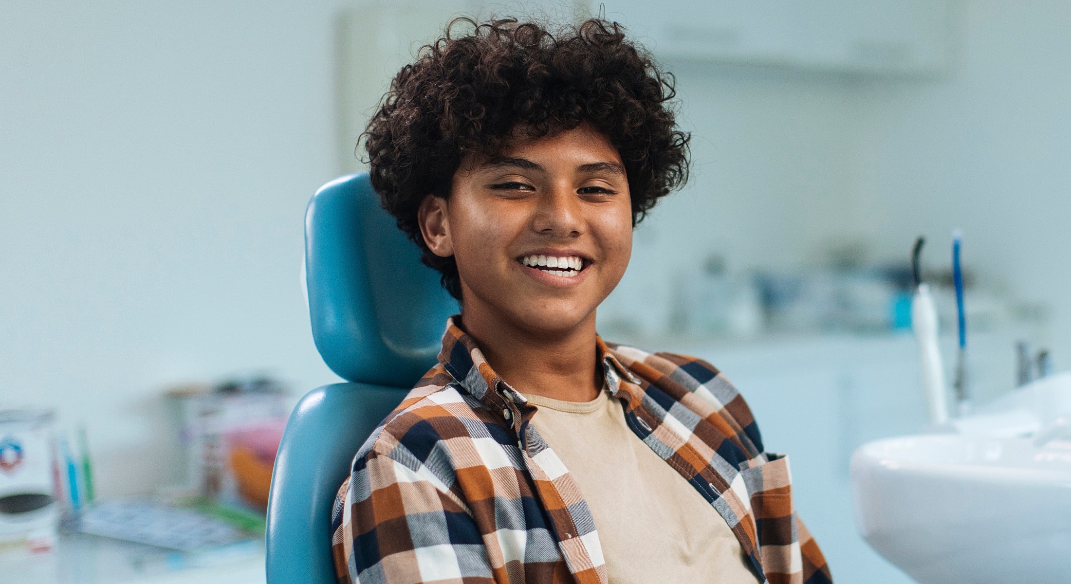 Smiling boy in dentist chair, ready for appointment.