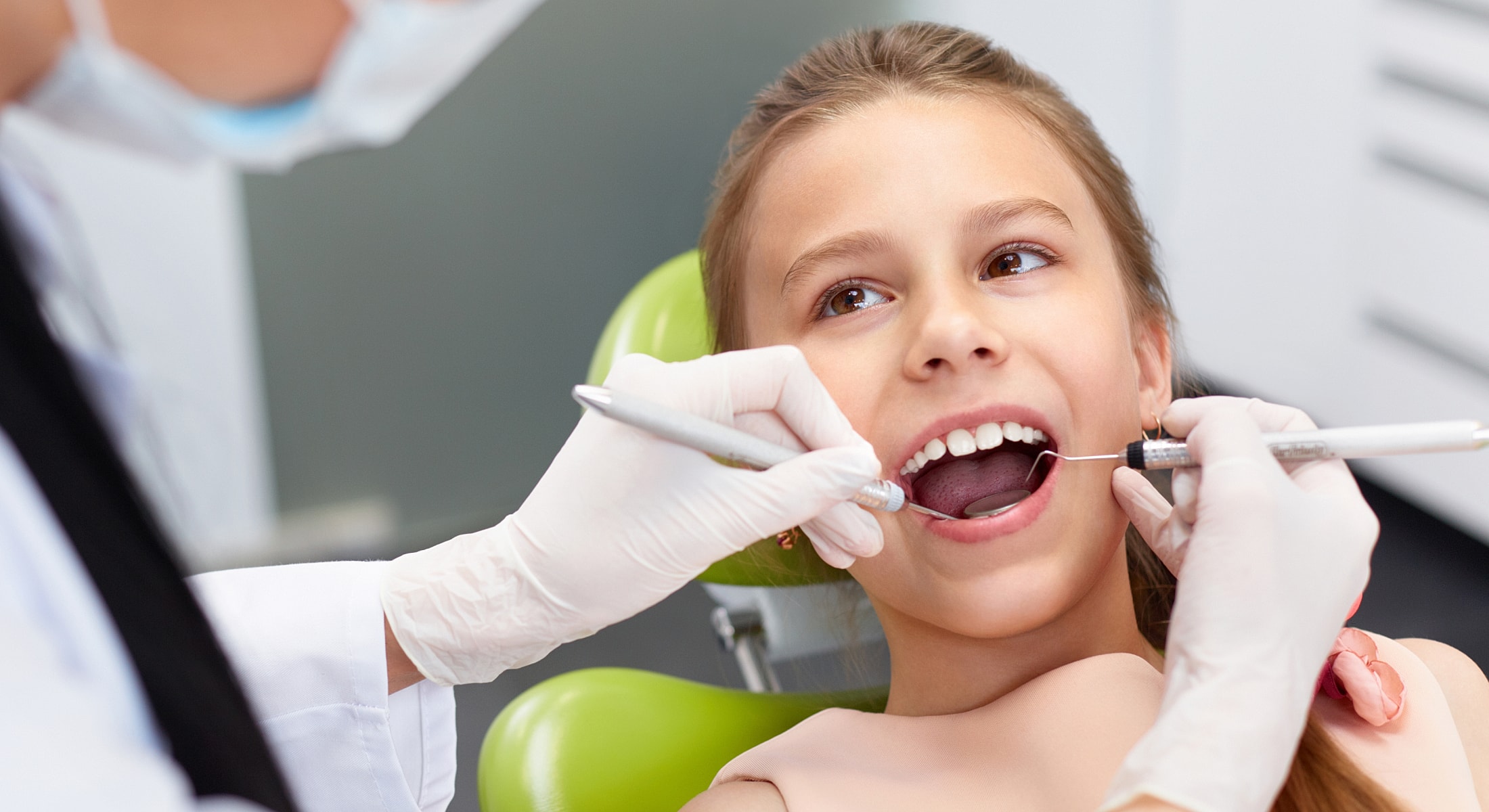 Child receiving dental check-up in clinic.